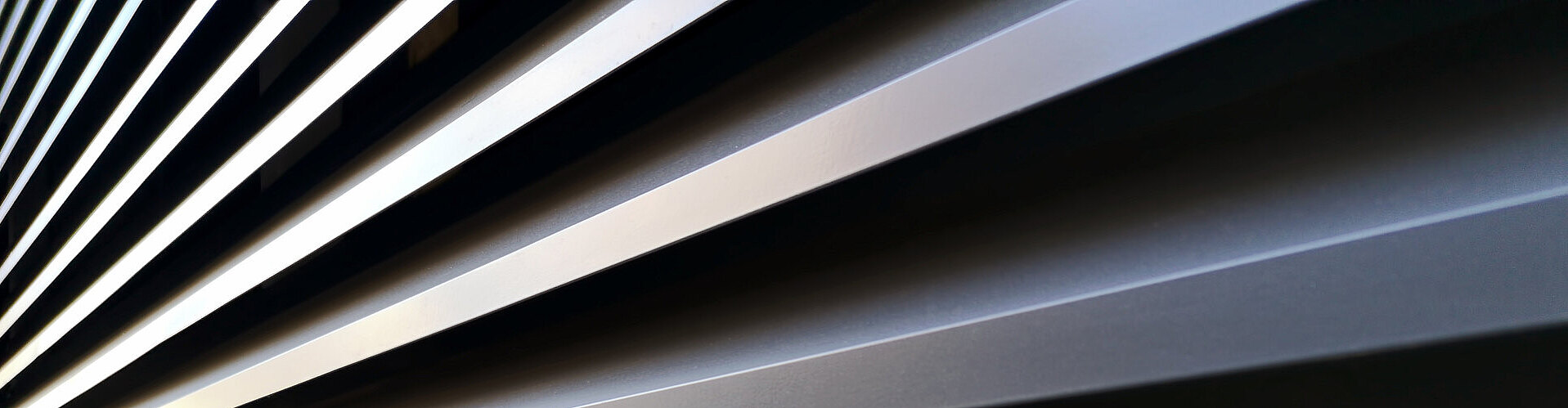 Gestapelte Aluminiumprofile mit reflektierender Oberfläche, bereit für industrielle Weiterverarbeitung